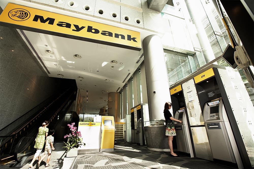 woman using ATM in Maybank's lobby in Singapore's financial district