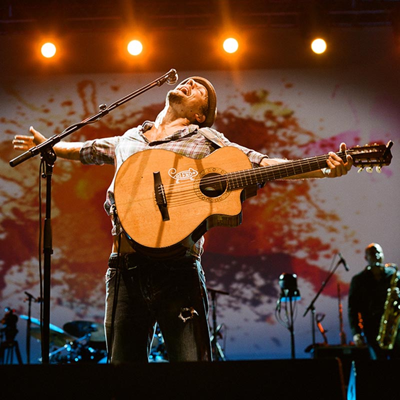 Jason Mraz singing with arms outstretched, head thrown back